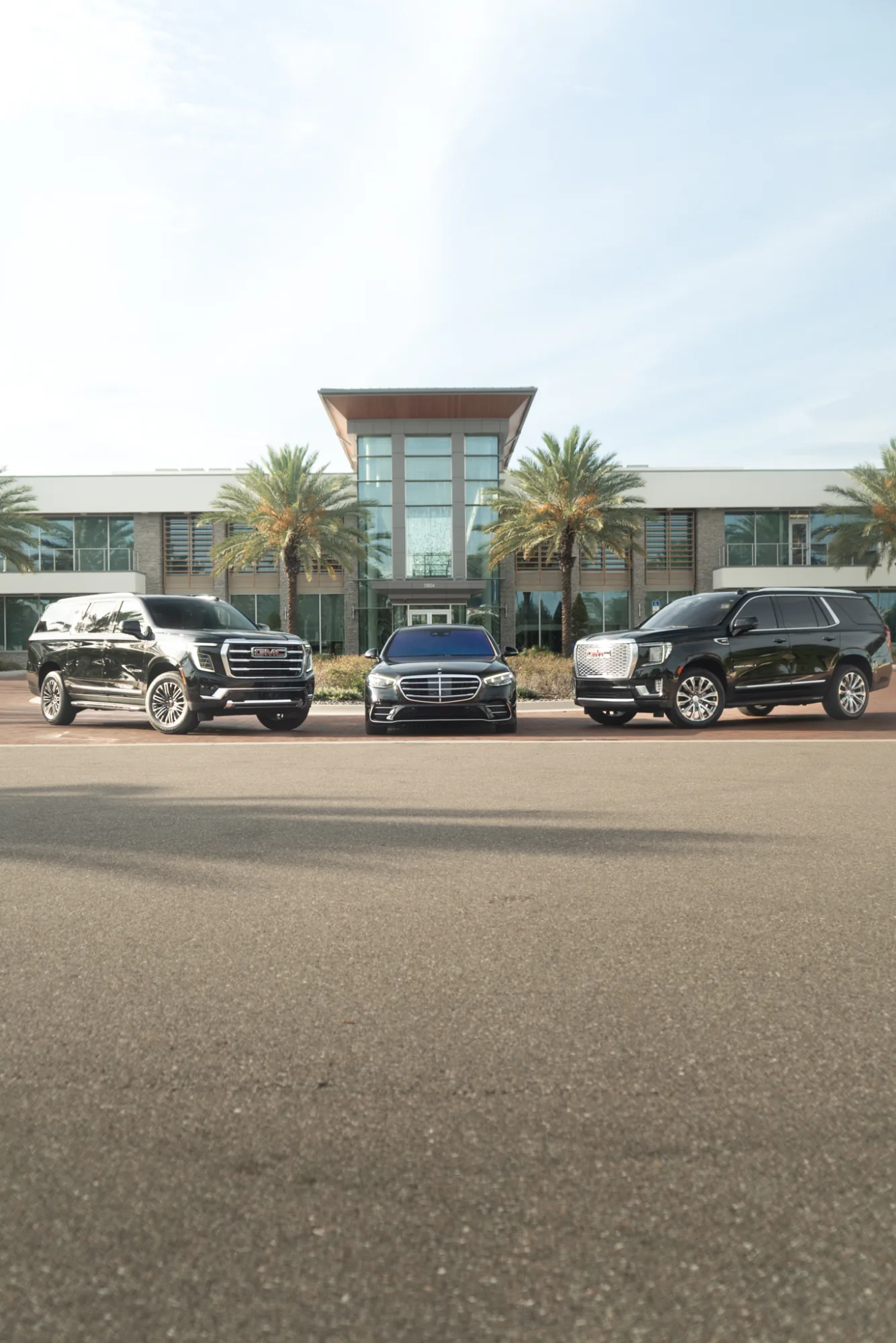 Executive SUVs and a Mercedes S-Class sedan ready for chauffeur pickup